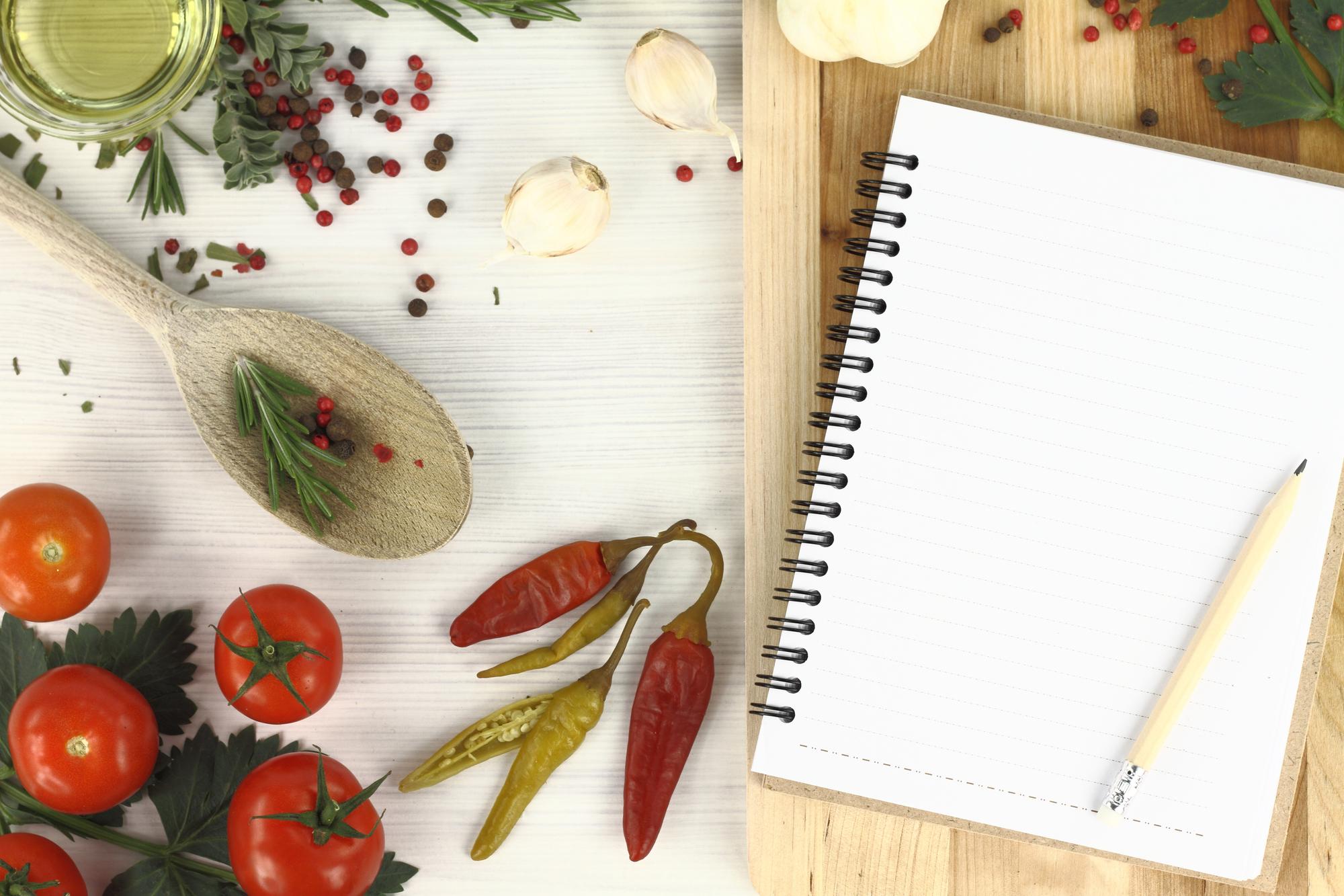 Tavolo con ingredienti freschi e quaderno di ricette
